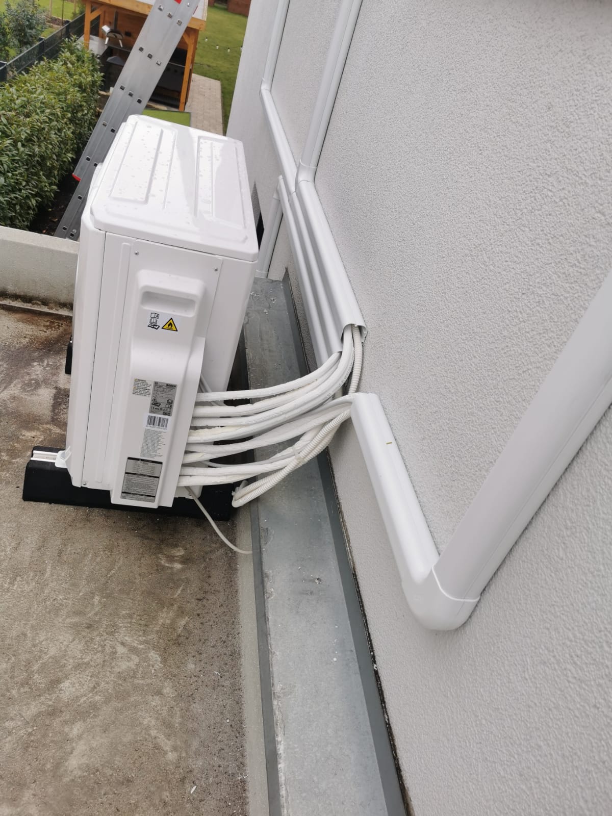 Außengerät einer Klimaanlage ist an der Hausfassade montiert, mit fokus auf die Leitungsverteilung.